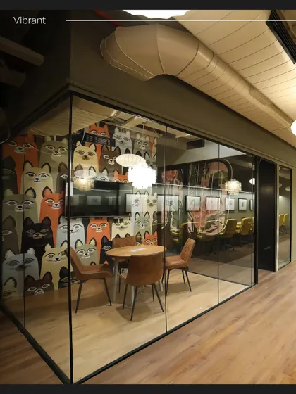 A vibrant meeting room at Innov8, enclosed in glass but distinguished by a playful wallpaper featuring a pattern of colorful cats. This shows our ability to inject personality and fun into a corporate setting.
