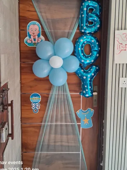 A simple yet sweet door decoration to announce the arrival of a baby boy. It features blue foil letters, a balloon flower, and cute baby-themed cutouts.