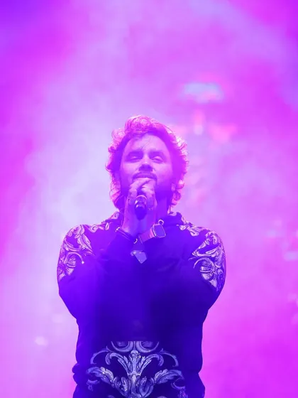 A powerful shot of Javed Ali bathed in purple light, capturing the mood of his performance.