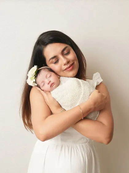 A mother's loving embrace. She holds her swaddled newborn, her expression full of peace and happiness. These are the quiet moments of motherhood I love to freeze.