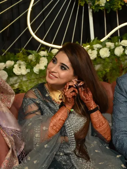 A candid moment of a bride at her function, her beautiful mehandi on display.