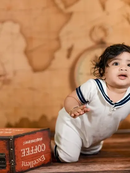 A crawling baby explorer in our travel-themed setup. We make sure our sets are safe and fun for even the littlest adventurers.