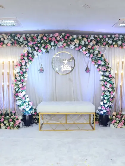 Another beautiful engagement stage setup, this time with elegant candle-like light stands on either side of the main arch, adding a warm glow to the atmosphere.