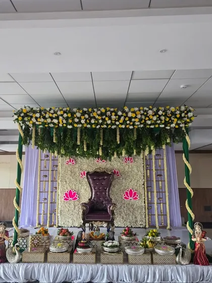 A straight-on view of the half-saree ceremony stage, showing the purple throne and symmetrical decor.