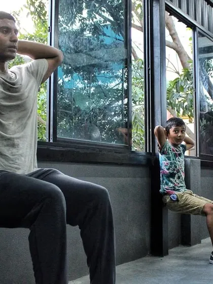 Fighters of all ages doing wall sits together. This builds camaraderie and shows that everyone, young or old, has to put in the same hard work.