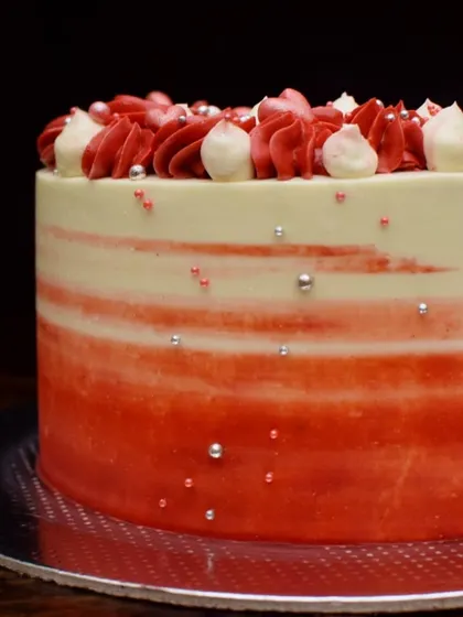 A side view of the red ombre cake, showing the smooth gradient of color. The silver sprinkles add a touch of sparkle to the design.