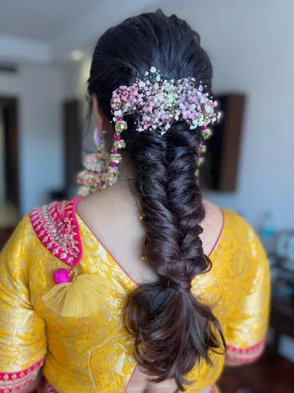 A messy fishtail braid is a great bohemian-chic option for a Haldi or Mehendi. I topped it off with a crown of colorful baby's breath.