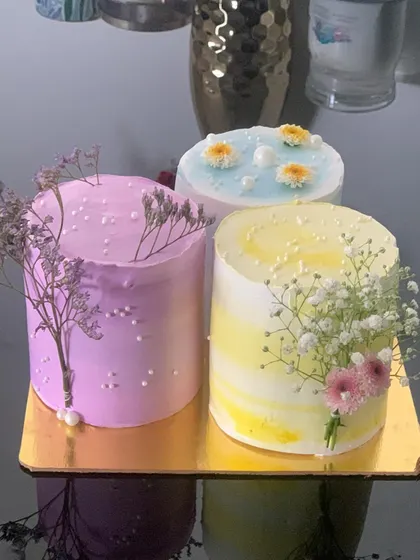 This trio of Korean-style bento cakes shows the simple, elegant aesthetic I love to create. Each cake is decorated with a different pastel buttercream and adorned with delicate, real flowers like baby's breath for a fresh and modern look.