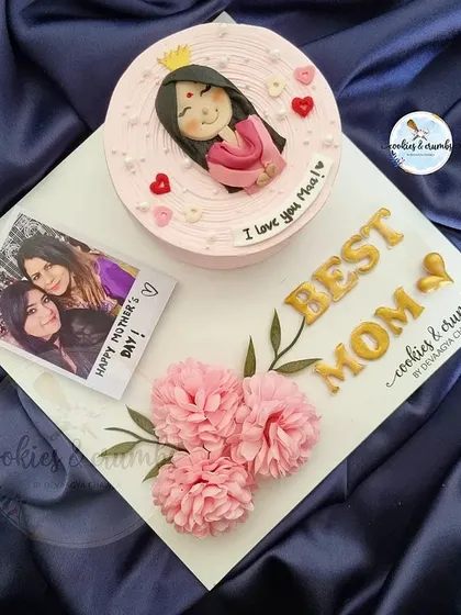 Another look at a custom Mother's Day bento platter. This one has a pink cake with a cute edible portrait, a photo, and is decorated with delicate paper flowers.
