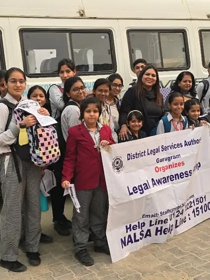 A happy group of schoolchildren posing with our legal awareness banner in front of the mobile van. Educating children about basic laws and safety from a young age is a proactive step towards a better society.
