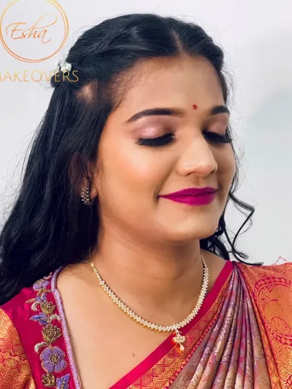 A bright and fresh look for a brother's wedding. The focus is on the bold magenta lip, which adds a pop of color and complements her pink and gold silk saree beautifully.