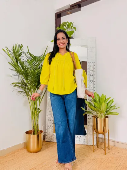 A bright yellow peplum top paired with blue jeans. This is a simple, cheerful, and comfortable outfit for a casual day.