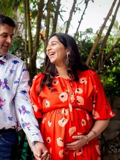 The pure joy of expecting! This candid shot of a couple sharing a laugh during their outdoor maternity walk is what it's all about.