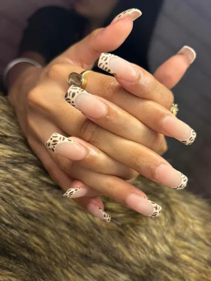 A side view showcasing the length and shape of these animal print French tip nail extensions.