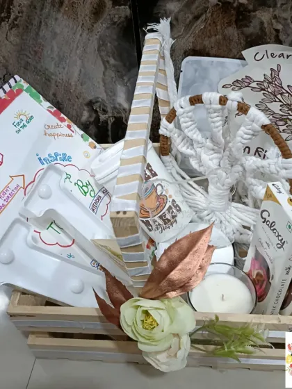 A full view of the white-themed hamper, featuring a V-shaped marquee light and a handmade dream catcher.