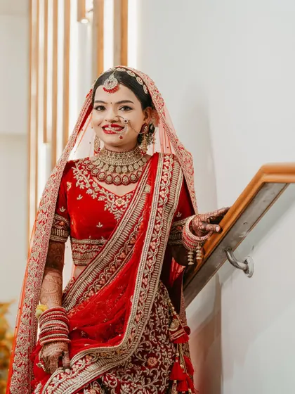 A full-length shot of this beautiful bride in her red velvet lehenga. The makeup is balanced to look stunning both up close and from a distance.