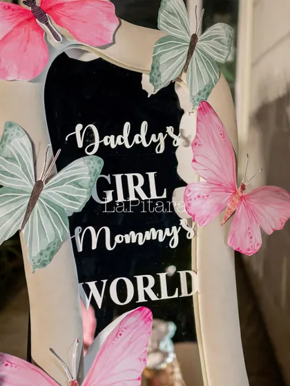 A mirror with the sweet inscription 'Daddy's Girl, Mommy's World', decorated with pastel butterflies. A perfect detail for a little girl's birthday.