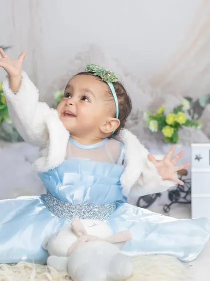 Another beautiful shot from Kridha's first birthday, celebrating with a sign and a happy, expressive pose.