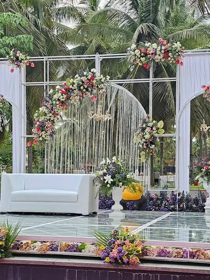 Another angle of the modern outdoor stage, showing the clear glass platform and the careful placement of floral arrangements to complement the natural scenery.