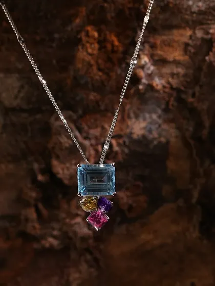This multi-gemstone necklace is set against a natural wood background, allowing the vibrant colors of the stones to pop while maintaining an organic feel for the brand's lookbook.
