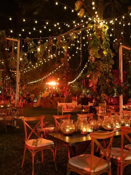 The seating arrangement under the stars for the Lohri party. The combination of rustic furniture, warm lighting, and lush surroundings created an intimate and joyful atmosphere for guests.