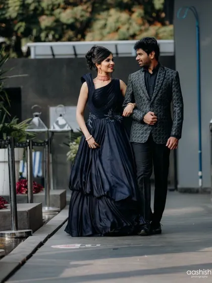 A candid walking shot of the couple. The bride's blue smokey eye makeup and elegant hairstyle are perfect for a fun and stylish sangeet or cocktail event.