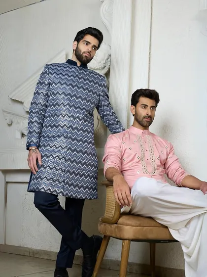 A showcase of two striking kurtas, one in a bold blue chevron pattern and the other in a soft pink with mirror work, demonstrating the range of styles I offer.