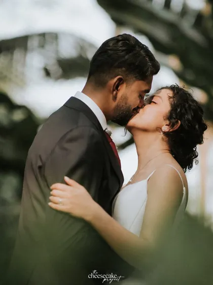 A passionate kiss, captured in a natural and romantic setting.