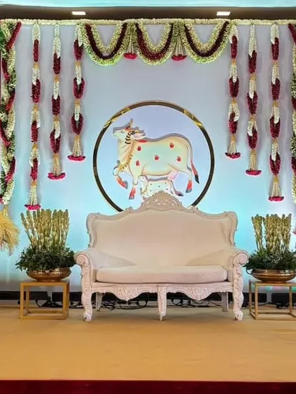 A Pichwai-style baby shower backdrop featuring traditional cow art, creating a unique and artistic theme.