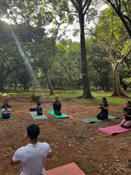 Participants in Vajrasana (Thunderbolt Pose) during an outdoor yoga class. Practicing together in nature helps us connect more deeply with the earth and our own inner stillness.