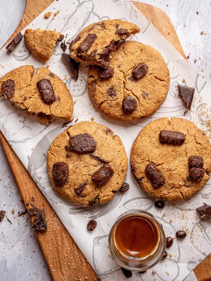 A rustic, deconstructed shot of chocolate chip cookies for Earth Cafe. Capturing crumbs and broken pieces makes the photo feel more natural and highlights the cookie's texture.