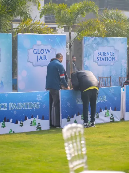 Activity stations for the kids, including face painting and a science station, all themed with snowy graphics to match the winter wonderland concept.