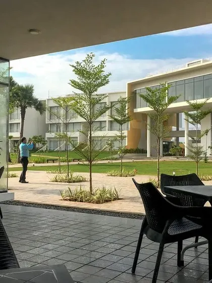 The dining area at the DRL Leadership Academy opens onto a landscaped central green. This seamless indoor-outdoor connection creates a pleasant, shaded space for informal activities that buzzes with life.