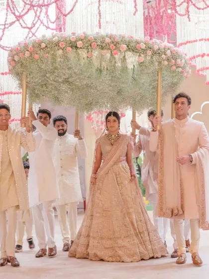 The bride's breathtaking entrance under a custom 'phoolon ki chadar' made of baby's breath and soft pink roses. This moment marks the beginning of the ceremony in our dreamy floral oasis.