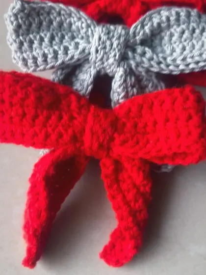 A close-up of the bright red and grey crochet bow hair clips.