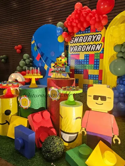 A full view of the main stage, showcasing the custom backdrop, light-up number, and various LEGO character and block props.