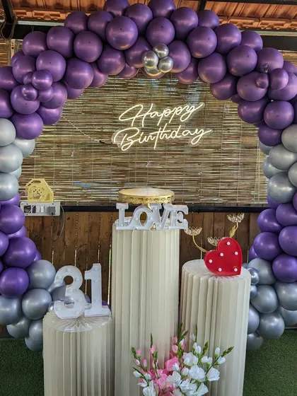 A 31st birthday party with a purple and silver balloon arch, marquee numbers, and a 'Love' prop.