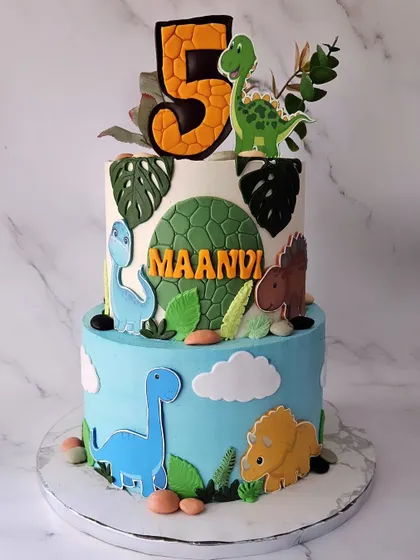 A rawr-some dinosaur party for Maanvi's 5th birthday. This two-tier chocolate truffle cake is covered in different types of dinosaurs and foliage, creating a prehistoric adventure.