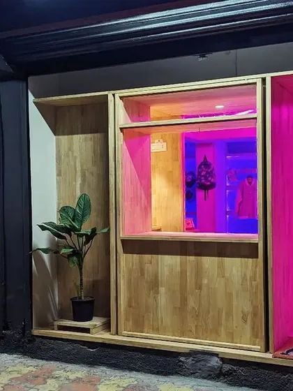 The facade glows with vibrant pink and blue light, demonstrating the transformative power of the RGB system. This feature allows the store to create different moods for product launches, events, or daily retail.