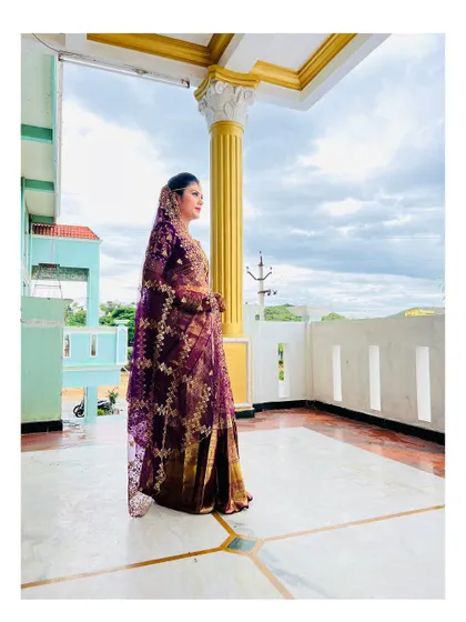 A side profile showcasing the elegant drape of the saree and the intricate details of the bridal look. The makeup is set to be flawless from every angle.