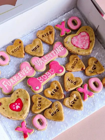 This is my assorted Valentine's biscuit box. It's full of fun, conversation-heart style cookies with words like 'Boop', 'Hug', and 'Kiss', plus personalized bone-shaped biscuits.