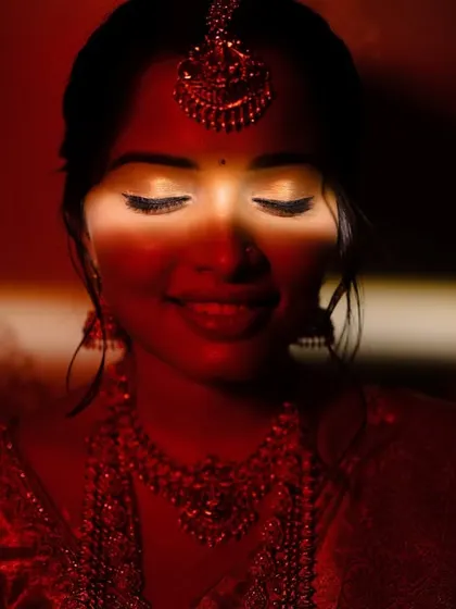 A dramatic close-up of the bride's face, with a sliver of light highlighting her eyes and smile. This artistic use of light and shadow creates a moody, intimate, and captivating portrait.