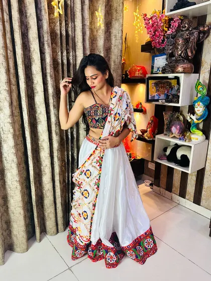 A full shot of the white satin lehenga, showing how the colorful blouse and border pop against the white fabric.