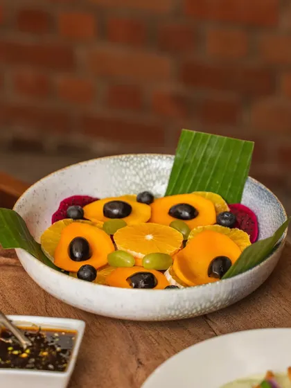 A vibrant fruit platter with a dipping sauce. The focus on fresh, colorful fruits like mango, dragon fruit, and grapes makes this a healthy and appealing option.