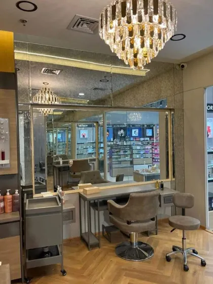 A close-up of a styling station featuring a stunning crystal chandelier. Details like this elevate the space from a simple salon to a luxurious experience.