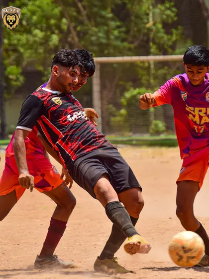 An intense moment of action as our player battles for possession against two opponents.