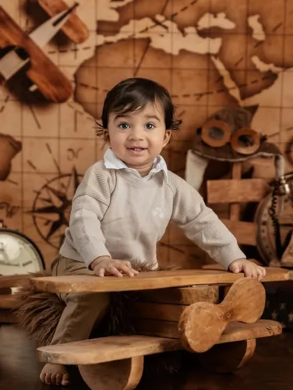 A happy smile from our little pilot as he sits in his wooden plane, ready to explore the world.