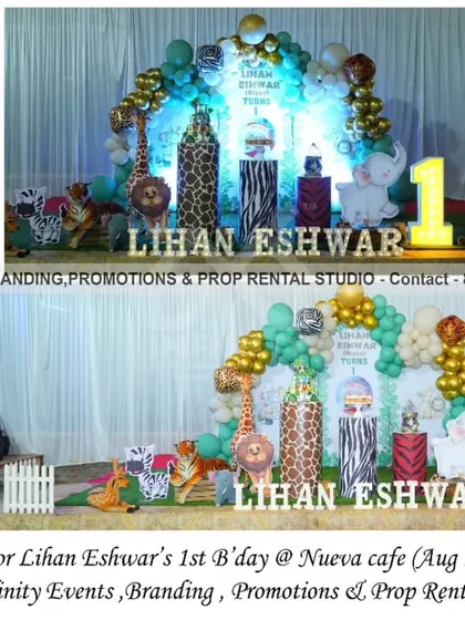 A wild safari theme for a first birthday at Nueva Cafe. This detailed setup includes a backdrop with a teal and gold balloon garland, multiple animal cutouts, animal-print props, and a light-up number "1."