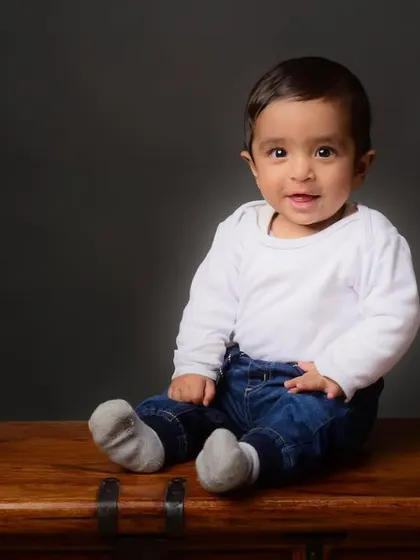A simple and sweet portrait of a baby boy sitting on a wooden chest, a versatile prop I use in my studio for kids' photography.