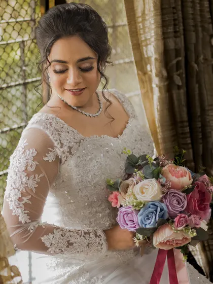 A beautiful portrait of the bride looking down at her bouquet. Her soft eye makeup and glowing skin are the highlights of this look.